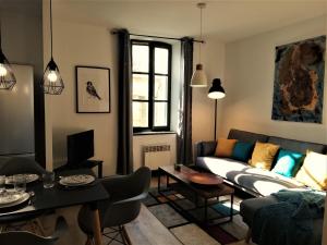 salon z kanapą i stołem w obiekcie Appartement sous les remparts w Carcassonne
