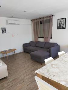sala de estar con sofá y mesa en logement atypique, en Arles