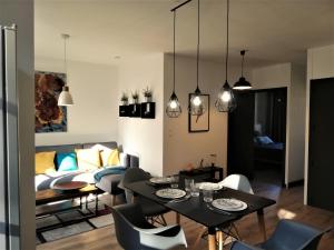 ein Wohnzimmer mit einem Tisch, Stühlen und einem Sofa in der Unterkunft Appartement sous les remparts in Carcassonne