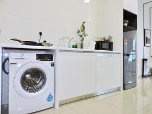 a kitchen with a washing machine under a counter at Arte Plus By Sleepy Bear in Batu Empat
