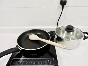 a pan on a stove with a pot on it at Arte Plus By Sleepy Bear in Batu Empat