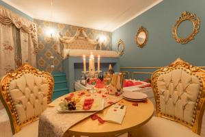 Love Suite Roma - Il Nido d'Amore في روما: غرفة طعام مع طاولة وكرسيين وشموع