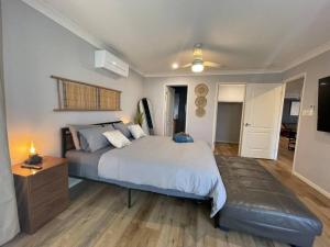 een slaapkamer met een groot bed en een houten vloer bij Peaceful Brand New Holiday house in North Lakes in North Lakes