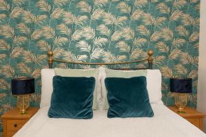 a bedroom with a bed with two pillows and a wallpaper at Lower Upover in Woolacombe