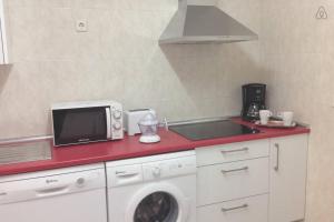 a kitchen with a microwave and a washing machine at Cason del Corpus in Toledo