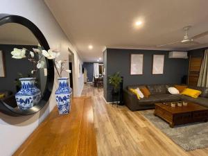 a living room with a couch and a mirror at Peaceful Brand New Holiday house in North Lakes in North Lakes