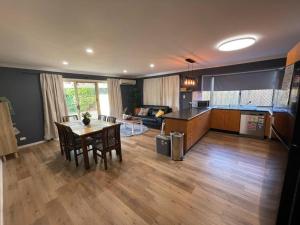 a large living room with a table and a kitchen at Peaceful Brand New Holiday house in North Lakes in North Lakes