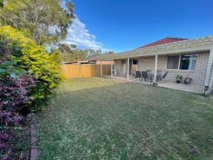 un patio trasero de una casa con una valla en Peaceful Brand New Holiday house in North Lakes en North Lakes