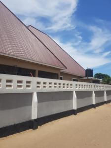 a white fence in front of a building at Cozy Master bedroom with Free Wi-Fi in Tanga in Tanga