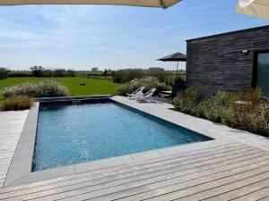 a swimming pool in a yard with a wooden deck at Annexe de Barth in Erbaut
