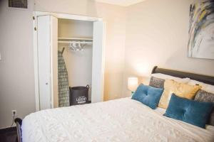 1 dormitorio con 1 cama blanca grande con almohadas azules en LOVELY 1 BR 2Bed. MONTROSE/HOUSTON GETAWAY en Houston
