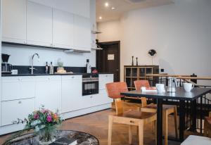 a kitchen with white cabinets and a table and chairs at Bob W Helsinki Katajanokka in Helsinki