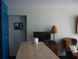 a living room with a wooden table and a television at Nénuphar in Autun