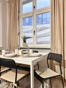 a dining room with a white table and chairs at CRYSTAL Św. Marcin Poznań in Poznań