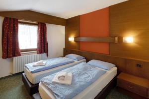 two beds in a room with orange walls at Casa San Marco n 8 in Livigno