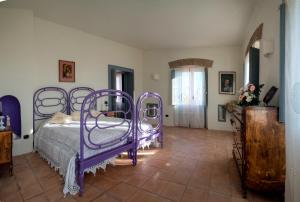 a bedroom with purple beds and a tile floor at Agriturismo Piano del Monaco in Marcellinara