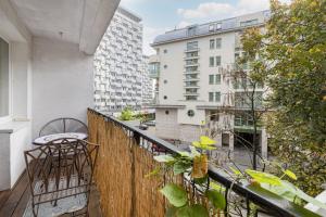 a balcony with a table and chairs on a building at Warsaw Cosy&Sunny Apartment Górnośląska by Renters in Warsaw