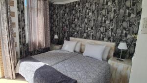 ラスパルマス・デ・グランカナリアにあるApartment 2-10 Canteras Beachのベッドルーム1室(白黒の壁紙のベッド1台付)