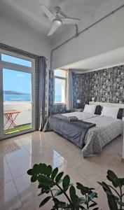 ラスパルマス・デ・グランカナリアにあるApartment 2-10 Canteras Beachのビーチの景色を望むベッドルーム1室(大型ベッド1台付)