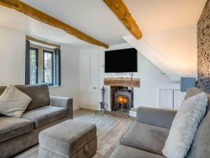 a living room with a couch and a fireplace at luxury 2 bed cosy cottage with hot tub and childrens play area hambrook Bristol in Bristol
