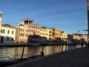 un grupo de edificios sentados junto a un río en Guglie Luxury Apartment, en Venecia
