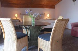 una mesa y sillas con un jarrón de flores. en Pension Steiger, en Bad Griesbach