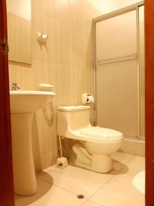 y baño con aseo y lavamanos. en 100 RV Apartments Iquitos-Apartamento primer piso con vista a piscina en Iquitos