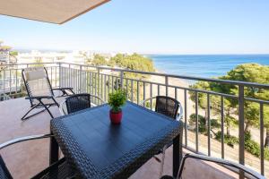 a blue table and chairs on a balcony with the ocean at Deauville Miami platja in Miami Platja
