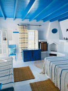 a bedroom with two beds and a blue ceiling at Dar Elbidha in Djerba