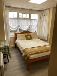 a bedroom with a large bed with a window at Clarendon Lodge - accommodation only in Skegness
