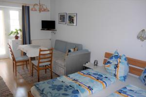 1 dormitorio con cama, sofá y mesa en Gertis Blumenhof Privatzimmer, Ferienwohnung, en Gmünd
