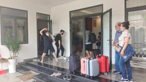 a group of people standing outside a building with luggage at Sealight Villa and House Phu Quoc in Phu Quoc