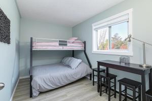 a bedroom with a bunk bed and a desk at The Alpine - Central Collingwood Condo in Collingwood