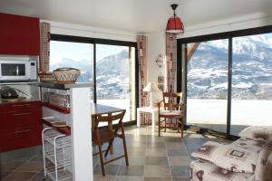 a kitchen and dining room with a view of mountains at T2 Balcon de l'Embrunais in Saint-Sauveur