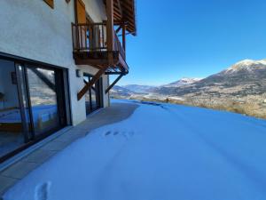 a view from the balcony of a house with snow on the ground at T2 Balcon de l'Embrunais in Saint-Sauveur