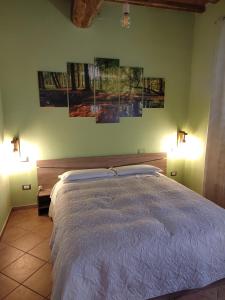 una camera da letto con un letto con tre dipinti sul muro di Serendipity House a Grosseto
