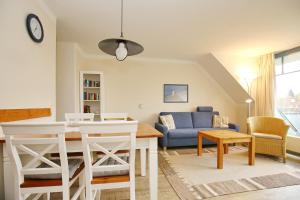 - un salon avec une table et un canapé bleu dans l'établissement Papillon Wohnung 01-6, à Boltenhagen