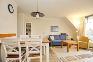 a living room with a table and a blue couch at Papillon Wohnung 01-6 in Boltenhagen