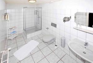 La salle de bains est pourvue d'une douche, de toilettes et d'un lavabo. dans l'établissement Hotel-Restaurant Zum Dorfkrug, à Winterberg