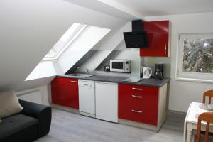 una cocina con armarios rojos y blancos y una ventana en Helles Apartment in Berlin-Mariendorf, en Berlín