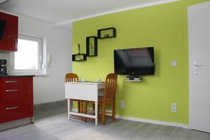 a kitchen with a tv on a green wall at Helles Apartment in Berlin-Mariendorf in Berlin