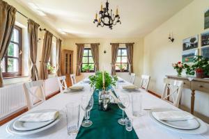 a dining room with a long table with plates and glasses at Conacul Gaal Kuria in Dalnic +19 photos