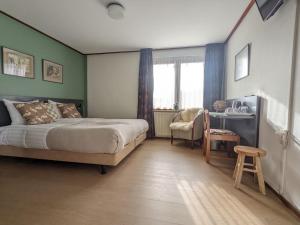 een slaapkamer met een bed, een bureau en een stoel bij Hotel De Gravin van Vorden in Vorden