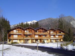 a large building in the snow with mountains in the background at Appartement Samoëns, 3 pièces, 6 personnes - FR-1-624-30 in Samoëns