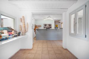 a hallway with white walls and a cactus in a room at Coralli Seaside Resort in Livadakia