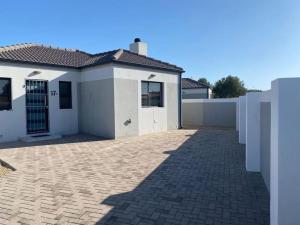 a white house with a brick driveway at 17 On Sleigh in Langebaan