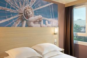 a statue on the headboard of a bed in a bedroom at B&B HOTEL Marne-la-Vallée Chelles in Chelles