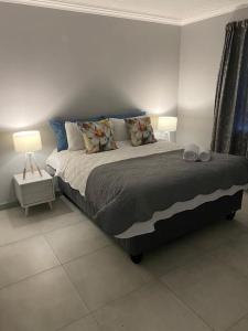 a bedroom with a bed with two lamps on it at 17 On Sleigh in Langebaan