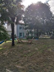 dos mesas de picnic en un patio frente a una casa en Au Clos des Figues, en Chambon