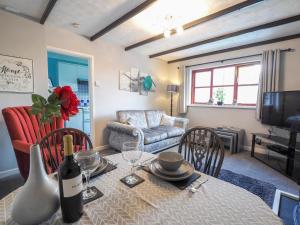 uma sala de estar com uma mesa e uma garrafa de vinho em Trenewydd Farm Holiday Cottages em Cardigan